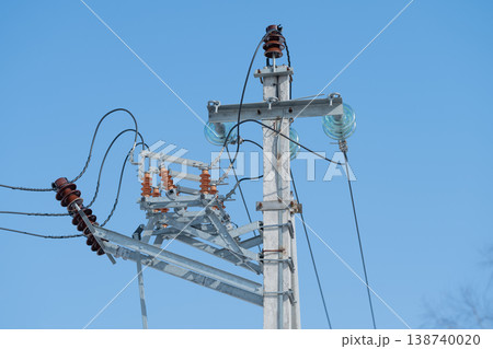 Power lines tensioned now. Industrial energy flows through conductors. Angle view showcasing electrical cables and ceramic insulators with industrial energy in motion 138740020