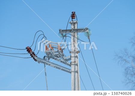 Concrete pole with power lines crossing clear blue sky, multiple conductors and glass insulators, wideangle view suggesting distribution network and dependable utility presence Concrete pole with power lines crossing clear blue sky, multiple conductors and glass insulators, wideangle view suggesting distribution network and dependable utility presence 138740026