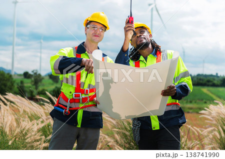 Two engineers stand in a wind farm field 138741990