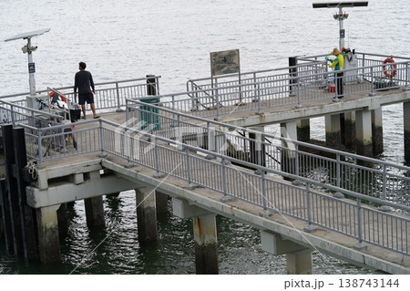People on Pier Over Water Gray Day Urban Landscape People on Pier Over Water Gray Day Urban Landscape 138743144