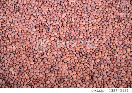 Closeup red lentil cereal texture showing uniform dry lentils on burlap, warm earthy tones, rustic pantry prep for artisan soup recipe, macro detail and soft natural light 138743181