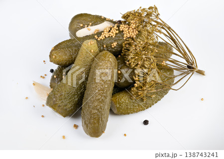 Pickled cucumbers captured with dill heads and scattered seeds on white background, rustic arrangement suggests seasonal harvest preserve, pantry staple, and slow food sensibility Pickled cucumbers captured with dill heads and scattered seeds on white background, rustic arrangement suggests seasonal harvest preserve, pantry staple, and slow food sensibility 138743241