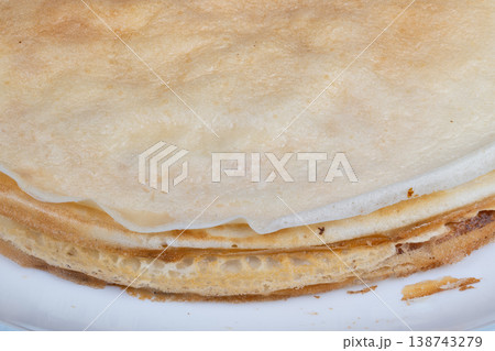 Golden pancake for Maslenitsa edge closeup revealing thin layered rim, browned crisp edge, delicate sponge texture, subtle butter sheen, warm homestyle atmosphere Golden pancake for Maslenitsa edge closeup revealing thin layered rim, browned crisp edge, delicate sponge texture, subtle butter sheen, warm homestyle atmosphere 138743279