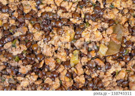 Close up cooked lentils with meat, crumbly mince, glossy brown lentils, diced onion, parsley flecks, warm steamy texture conveying rustic comfort and hearty home cooking Close up cooked lentils with meat, crumbly mince, glossy brown lentils, diced onion, parsley flecks, warm steamy texture conveying rustic comfort and hearty home cooking 138743311