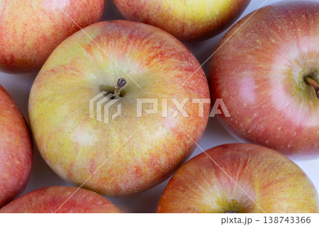 Vividly colored ripe apples arranged aesthetically for market presentation. Overlapping rows of freshly picked apples with shiny skin and appealing quality on display Vividly colored ripe apples arranged aesthetically for market presentation. Overlapping rows of freshly picked apples with shiny skin and appealing quality on display 138743366