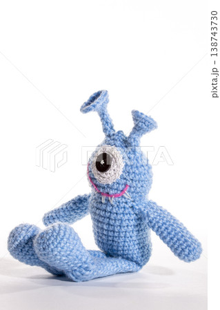 Knitted wool aliens in a glass on a white background Knitted wool aliens in a glass on a white background 138743730