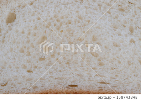 Bread crust detail. Rustic loaf with airy crumb. Closeup of artisan bread texture with golden crust. Detailed view of soft bread with uneven air pockets and crust 138743848