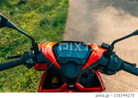 POV driving a red scooter on a rural countryside road during golden hour POV driving a red scooter on a rural countryside road during golden hour 138744275