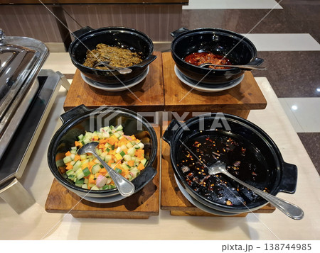 A candid and indulgent view of diverse Asian condiments and relishes at a hotel buffet presentation 138744985