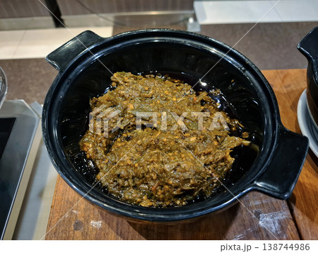 A bowl of spicy green chili sauce on the buffet. 138744986