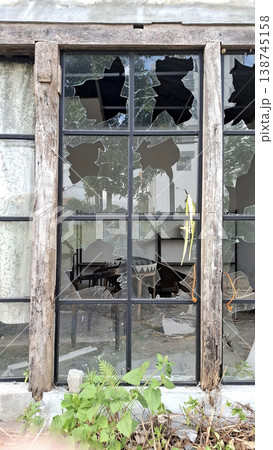 Vibrant Minimalist photo of broken window with green plants in front 138745158