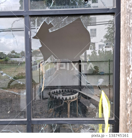 Gritty Cinematic scene of broken glass window with debris inside Gritty Cinematic scene of broken glass window with debris inside 138745161