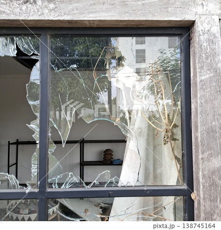 Gritty Cinematic scene of broken glass window with damaged frame and interior decor 138745164