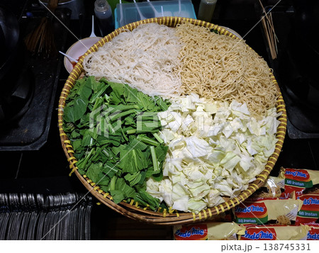 Appetizing Candid Street Food Preparation Fresh Noodles and Vegetables in Woven Basket Appetizing Candid Street Food Preparation Fresh Noodles and Vegetables in Woven Basket 138745331