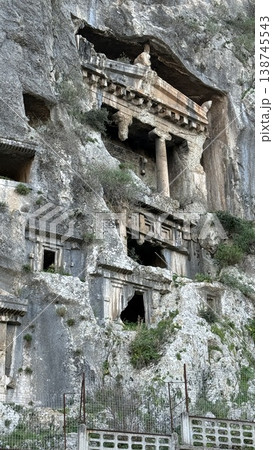 Ancient rock tombs carved into mountain cliff, showcasing historic architectural details Ancient rock tombs carved into mountain cliff, showcasing historic architectural details 138745543