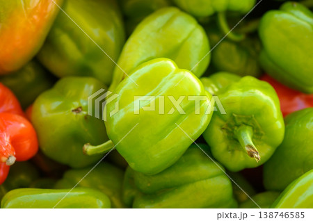 Freshly harvested bell peppers in vibrant colors displayed at a bustling farmers market during the late afternoon 138746585