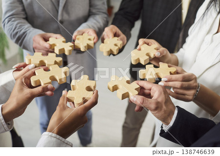 Close-Up Of Business Team With Wooden Puzzles Close-Up Of Business Team With Wooden Puzzles 138746639