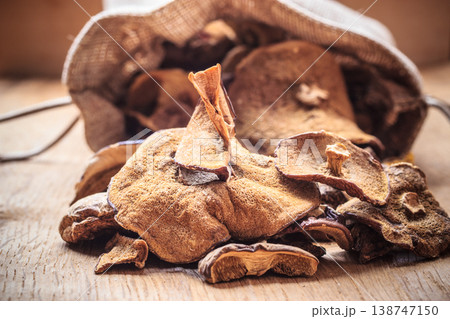 Dry mushrooms in sack on wooden table. Dry mushrooms in sack on wooden table. 138747150