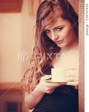 Woman drinking hot coffee beverage at home 138747438