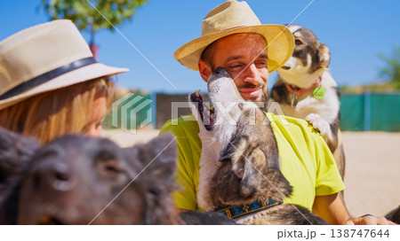 Couple interacting cheerfully with dogs at animal shelter 138747644