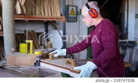 Experienced woodworker shaping wood board in workshop Experienced woodworker shaping wood board in workshop 138747836