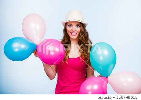 Woman playing with many colorful balloons Woman playing with many colorful balloons 138748015