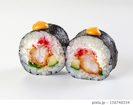 Two ebi tempura sushi rolls with tobiko, cucumber, and sauce isolated on a white background. Two ebi tempura sushi rolls with tobiko, cucumber, and sauce isolated on a white background. 138748334