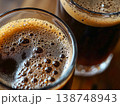 Dark craft beer in glasses with rich foam and bubbles closeup 138748943