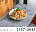 Thai style seafood spaghetti with shrimp clams and fresh herbs on white plate rustic stone background 138748948
