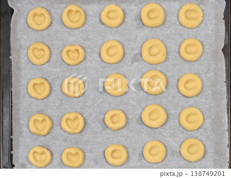 Raw Thumbprint Heart Cookies on Baking Sheet 138749201