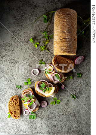Open sandwiches with herring filet, red onion, lemon, and parsley. 138749451