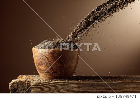 Chia seeds is poured into a wooden bowl. 138749471