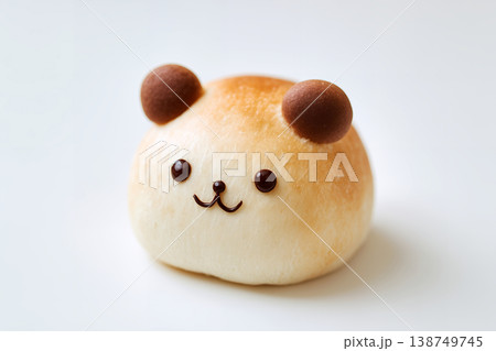 チョコペンで描かれたくまの表情と丸い耳が特徴的なふんわり焼けた動物パンの孤立背景素材 138749745