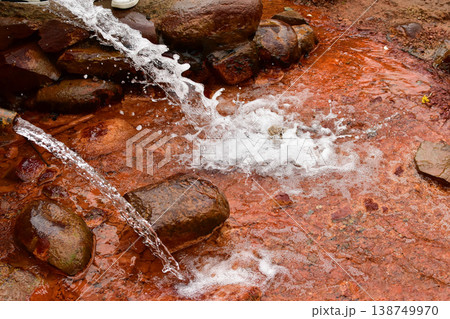 Clear water flows down rocks, creating white spray 138749970