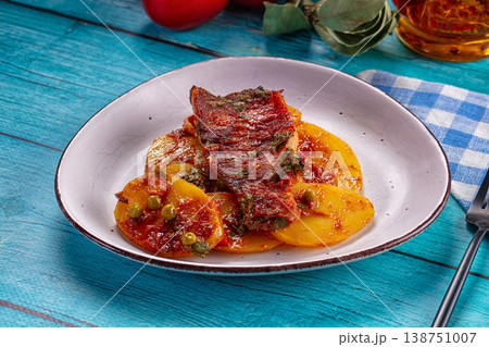 Baked fish fillet with tomato sauce and vegetables on a rustic blue wooden table Baked fish fillet with tomato sauce and vegetables on a rustic blue wooden table 138751007