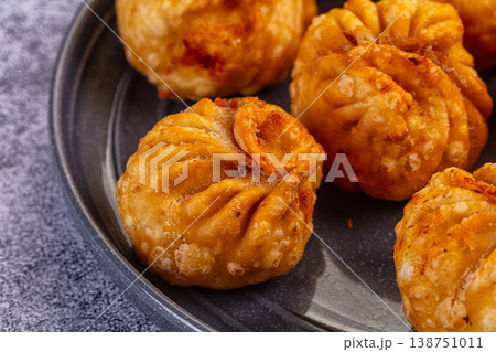 Golden fried dumplings momo in a skillet with fresh vegetables and flatbread Golden fried dumplings momo in a skillet with fresh vegetables and flatbread 138751011