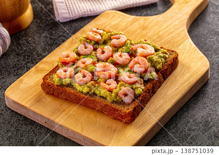 Shrimp and avocado toast on a wooden board with garlic, lime, and chili pepper Shrimp and avocado toast on a wooden board with garlic, lime, and chili pepper 138751039