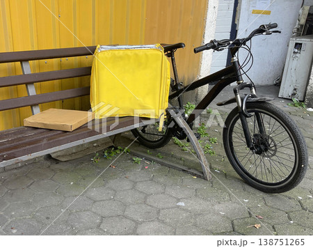 yellow backpack near the bike on the sidewalk. delivery concept 138751265