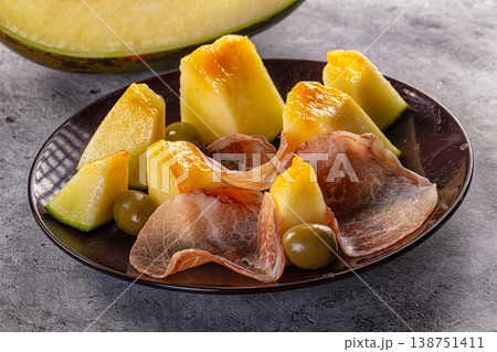 Classic prosciutto and melon appetizer with olives on a rustic gray background Classic prosciutto and melon appetizer with olives on a rustic gray background 138751411