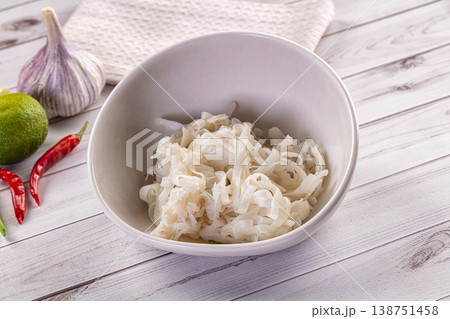 Bowl of rice noodles with fresh ingredients like garlic, lime, and chili for Asian cooking Bowl of rice noodles with fresh ingredients like garlic, lime, and chili for Asian cooking 138751458