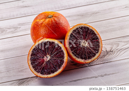 Whole and halved fresh blood oranges on a white wooden background 138751463