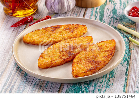 Crispy fried potato pancakes served with chili and garlic on a rustic wooden table. Crispy fried potato pancakes served with chili and garlic on a rustic wooden table. 138751464