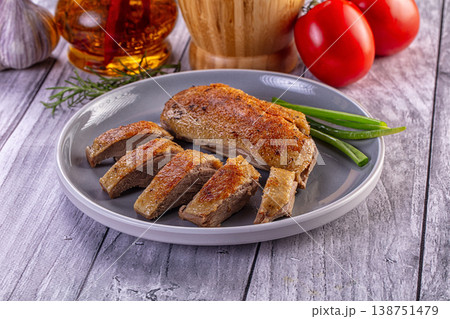 Gourmet sliced roasted duck breast with crispy skin served on a white plate with green onion garnish. Gourmet sliced roasted duck breast with crispy skin served on a white plate with green onion garnish. 138751479