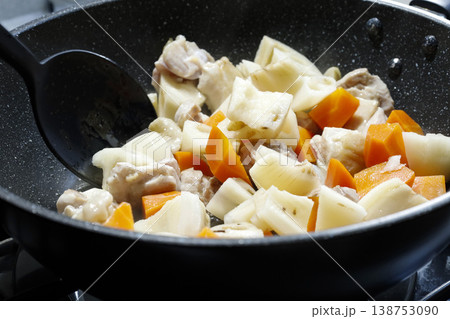 深めのフライパンで加熱中の鶏もも肉と根菜 138753090