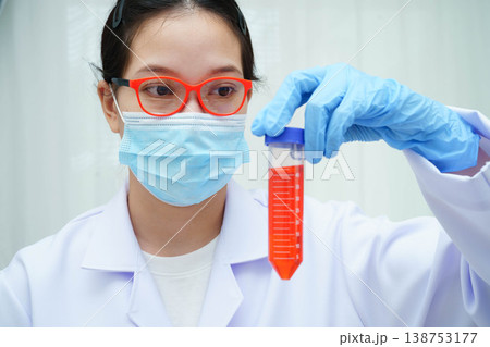 Doctor holding thyroid gland model and blood sample test tube in laboratory. Doctor holding thyroid gland model and blood sample test tube in laboratory. 138753177