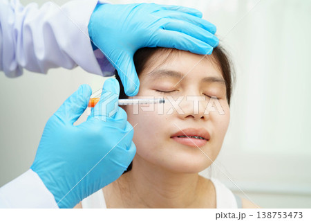 Asian woman receiving filler beauty injection. 138753473