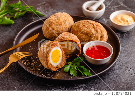 Traditional Scotch Eggs on a black plate. 138754021