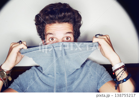 Man, fashion and hiding in studio portrait with clothes, spotlight and mystery by white background. Person, crazy and face with halo with unique trendy style, glow and jewelry for punk aesthetic Man, fashion and hiding in studio portrait with clothes, spotlight and mystery by white background. Person, crazy and face with halo with unique trendy style, glow and jewelry for punk aesthetic 138755217