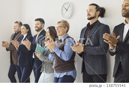 Diverse business team standing and applauding in office, celebrating success Diverse business team standing and applauding in office, celebrating success 138755541