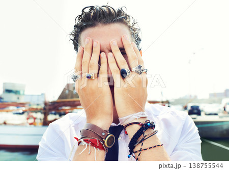 Hands, rings and accessories with a man in in the harbor by the sea for fashion or style. Jewelry, bracelet and fingers on the face of a young person for trendy or edgy expression by the pier Hands, rings and accessories with a man in in the harbor by the sea for fashion or style. Jewelry, bracelet and fingers on the face of a young person for trendy or edgy expression by the pier 138755544